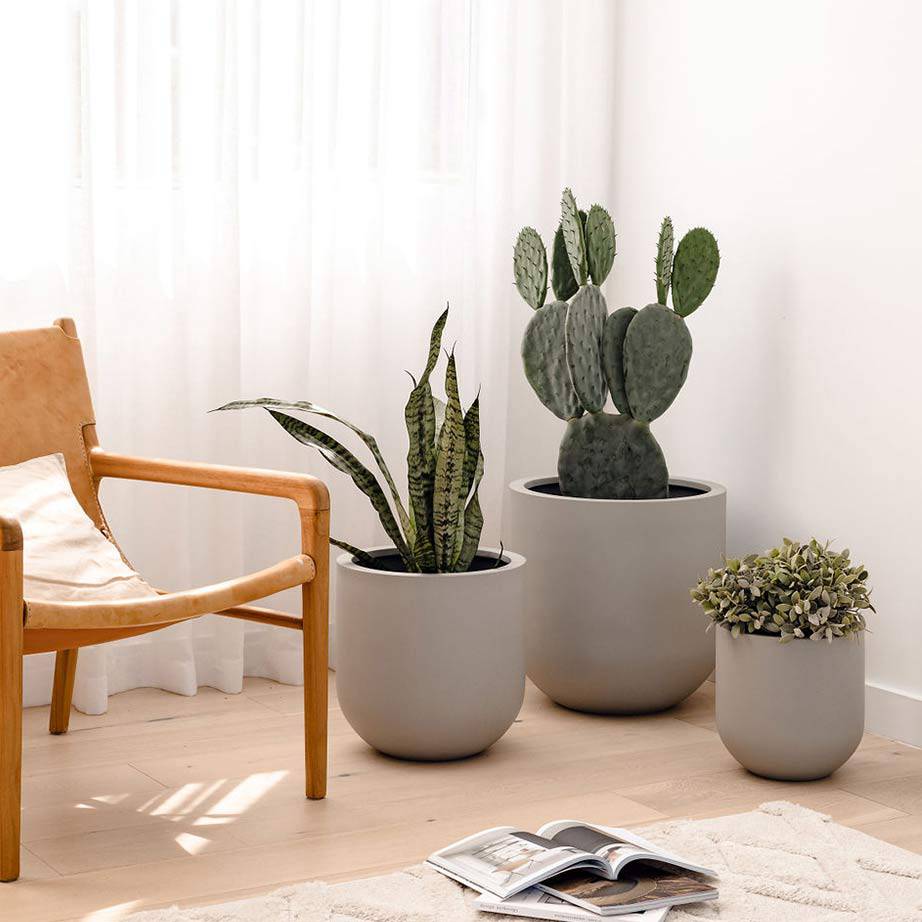  A cluster of three different-sized mud-coloured pots gives depth to a lightly coloured timber and Nordic style living space.